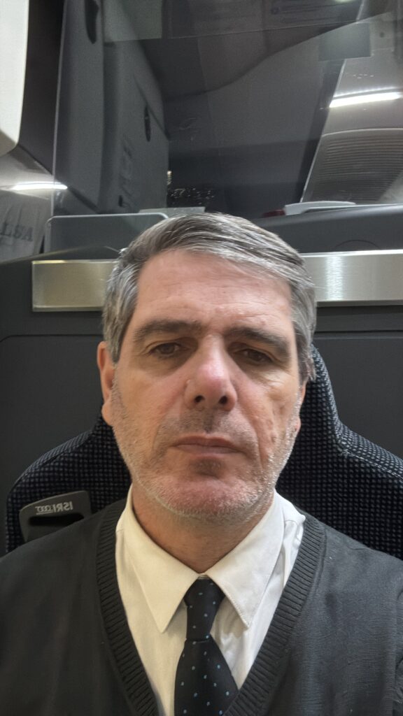 Miguel Arpón con el uniforme, en el puesto de conductor